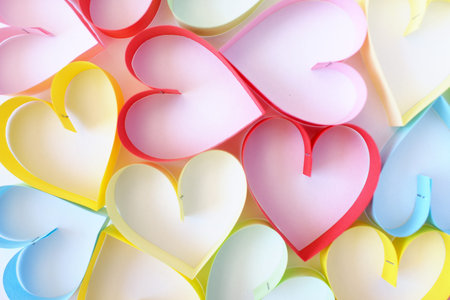 the multi-colored paper hearts on a white background
