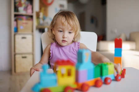 the little girl plays in the house multi-colored blocksの写真素材