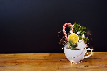 Big white mug with a nativity scene. New Year's decorations in a mug on a wooden background. The concept of Christmas gifts.の写真素材