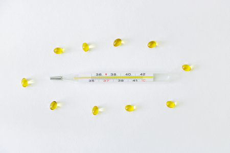 Glass thermometer surrounded by medications