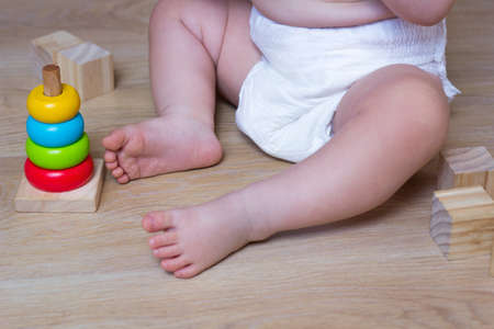 Infant playing with Ecological toys made from natural material. Kids Wooden Blocks and baby pyramidの写真素材