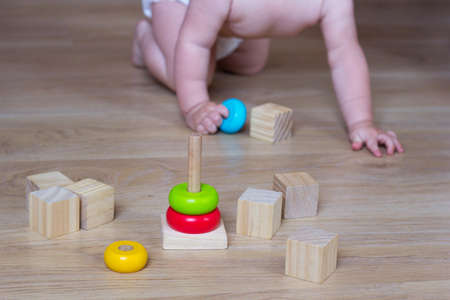 Baby playing with Ecological toys made from natural material. Kids Wooden Blocks and pyramidの写真素材