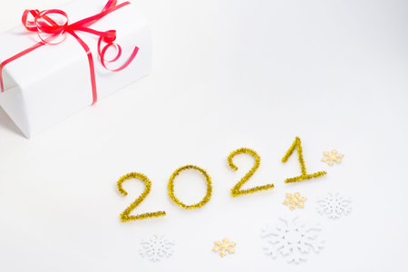 2021 number for New year greeting card. Christmas gift decoration on white background. Golden tinsel...