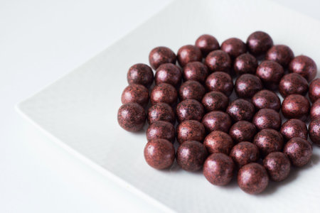 Handmade chocolate candy on white plate close-up. Tasty luxury dessert. Chocolatier sweet shop...
