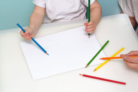Lesson in art class. Boy drawing using color pencils.