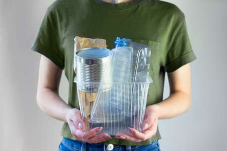 Woman holding capboard with Recyclable garbage consisting of glass, plastic, metal and paper. Eco volunteerの写真素材