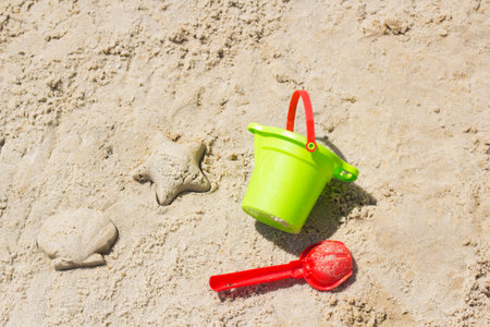 Children beach toys buckets, spade, shovel on sand. Sunny day on the seaside. Star and shell formの写真素材