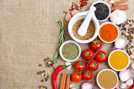 spices in bowls, hot peppers, tomatoes and other cooking ingredientsの写真素材