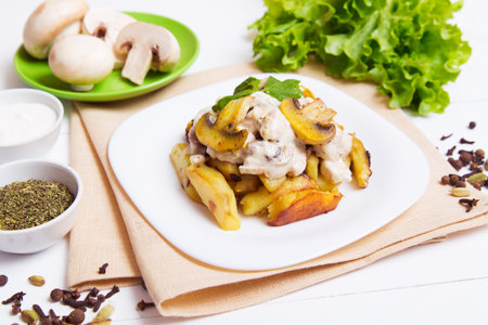 Fried potatoes with gravy of mushrooms in a plate on the table