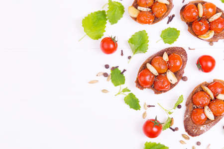 Classic italian bruschetta with tomatoes, garlic and mint on a white wooden backgroundの写真素材