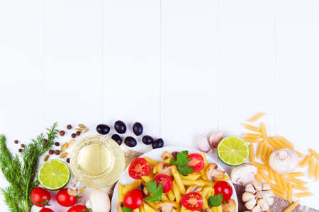 Classic Italian food - pasta with mushrooms, tomatoes, olives  and other ingredients on a wooden backgroundの写真素材