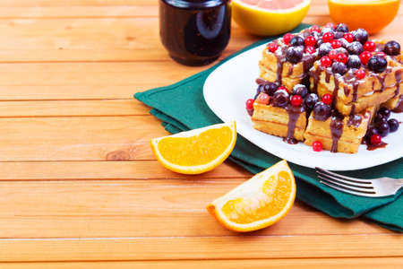 Belgian waffles with red and black currant and chocolate sauceの写真素材