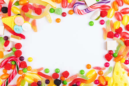 Colorful candies, jellies and lolly pops arranged as frame with copy space. Top viewの写真素材