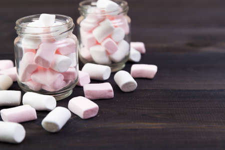 White and pink marshmallows in a glass on the  wooden backgroundの写真素材