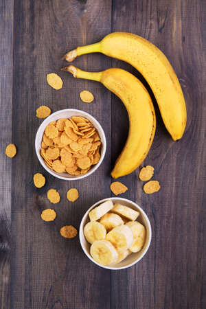 Healthy breakfast - cereal and a banana on a dark wooden backgroundの写真素材