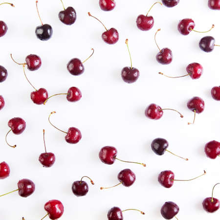 Colorful pattern of red cherries on a white background. Top view with copyspaceの写真素材