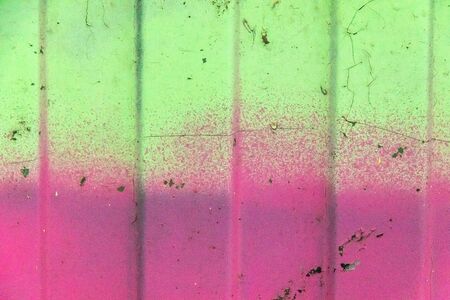 metal profiled sheet on which various bright graffiti paints are applied, over time the paints cracked a littleの写真素材