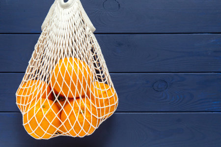 Oranges in a white mesh reusable bag eco friendlyの写真素材