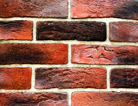the texture of the brick wall is close to the background. wall with bricks of different shades of...