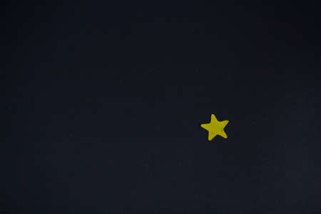 Yellow star on a black background. Minimalism. Copy space.の写真素材