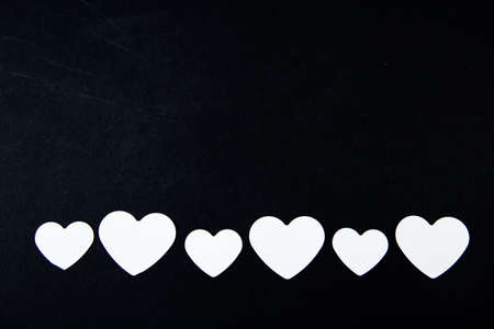 White paper hearts on a black background. Valentines day concept.の写真素材