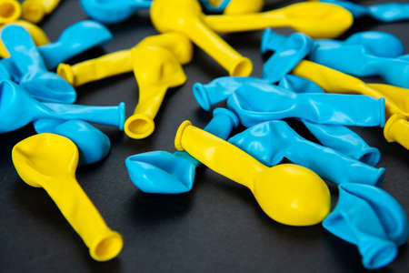 Blue and yellow balloons on a black background. Top view. Flat lay.の写真素材