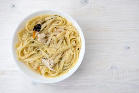 Appetizing chicken soup with noodles, with the addition of potatoes, carrot greens and bay leaf.の写真素材