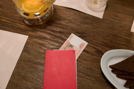 Five thousand Russian rubles in a red folder for an account settlement in a restaurant.