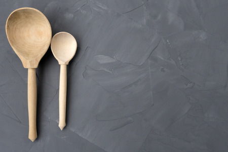 Two wooden spoons are located on a gray background.の写真素材