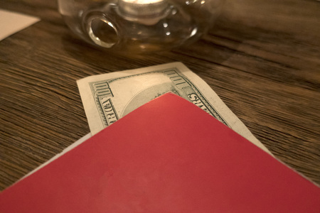 The money lies in a folder for tea, on a wooden tableの写真素材