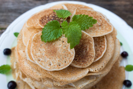 Green peppermint leaves are decorated with pancakes.