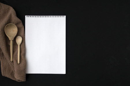 Notepad and wooden spoon on a gray background.の写真素材