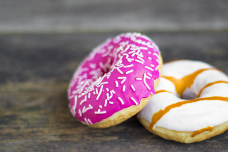 Two appetizing donuts close-up on a wooden background in rustic style and copy spaceの写真素材