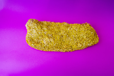 Meat schnitzel in breading close-up on a violet backgroundの写真素材