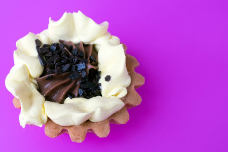 Cake basket of short pastry cream and chocolate close-up on purple background