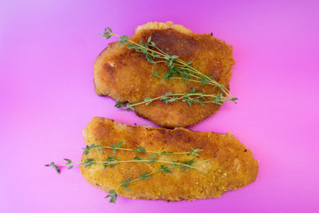 Schnitzel in a pan-bread fried close-up on a violet backgroundの写真素材