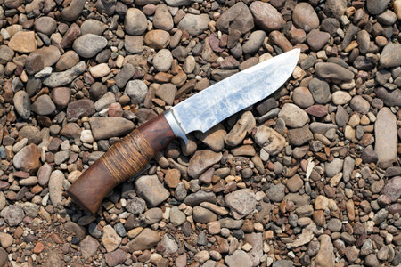 Hunting knife close-up, located on rocks in the summer