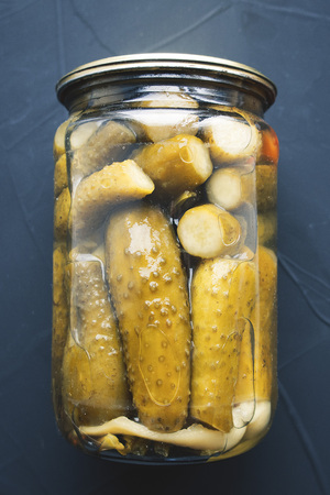 Bank with pickled cucumbers close-up on gray backgroundの写真素材
