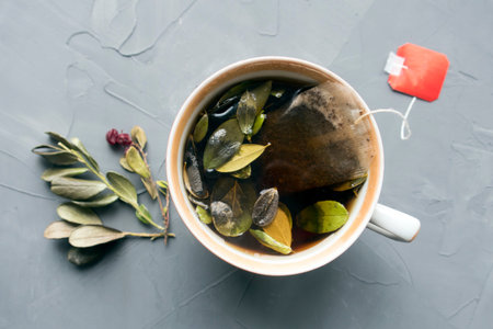 Lingonberry tea and leaves close-up on a gray background
