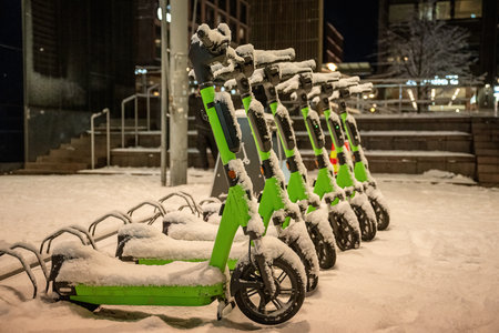Electric scooters covered with snow at night in Helsinki, Finlandの写真素材