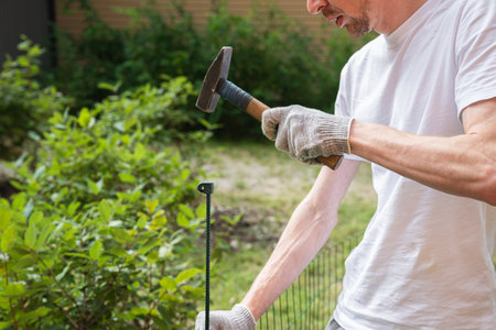 Close-up of a man working with a hammer in the gardenの写真素材