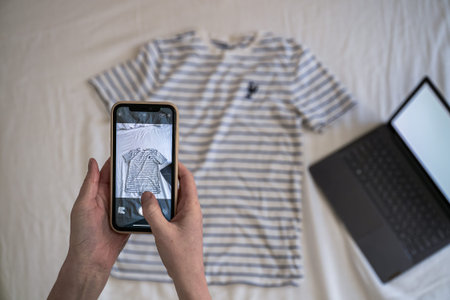 Woman taking a photo of old unwanted clothes to sell online