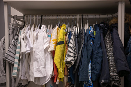 Variety of children's clothes on hangers organized on a rack in thrift storeの写真素材