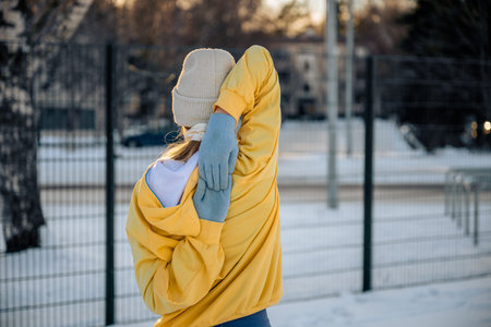 Woman stretching outdoors in winter clothing. Fitness and wellness in cold weather