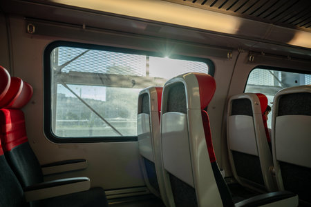 Empty red and black train seats beside window, concept of travel and transportation comfortの写真素材