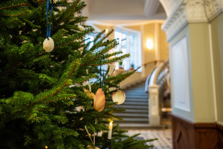 Close-up of decorated Christmas tree with seashell ornaments in elegant building interiorの写真素材