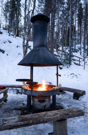 outdoor fire pit burning in snowy winter forest in Finnish laplandの写真素材
