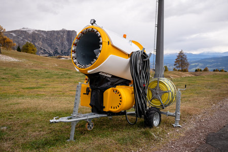 Snowmaking machine on alpine ski slope in Dolomites mountains
