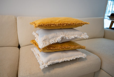 Stack of decorative pillows on sofa in cozy Scandinavian living room