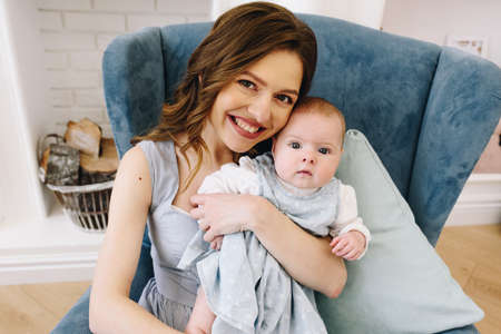 Young caucasian mother with her daughter looking straight into the camera smiling happyの写真素材